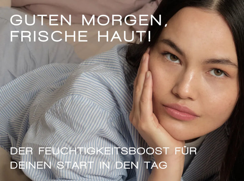 Eine Frau mit langen dunklen Haaren und klarer Haut stützt ihren Kopf auf ihre Hand und liegt auf der Seite im Bett. Der deutsche Text lautet: „Guten Morgen, frische Haut! Der Feuchtigkeitsboost für deinen Start in den Tag.“.