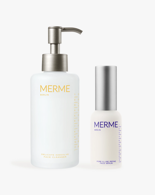 Das Pflege-Duo CLEANSE & CLARIFY von MERME Berlin: ein sanfter Gesichtsreiniger für empfindliche Haut und ein Niacinamid-Serum zur Verfeinerung der Poren, beide in eleganten weißen Flaschen mit silbernen Details.