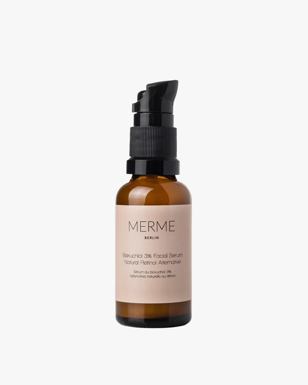 Eine braune Glasflasche mit schwarzer Pumpe und beigem Etikett trägt die Aufschrift „MERME Berlin BAKUCHIOL 3% FACIAL SERUM – Natürliche Retinol-Alternative“. Dieses Serum unterstützt die Kollagenproduktion und die Zellerneuerung der Haut. Abbildung auf weißem Hintergrund.