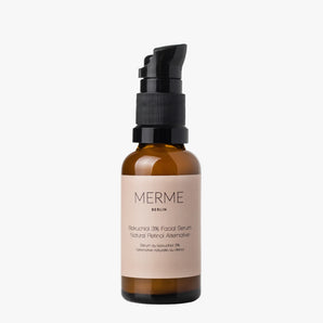 Eine braune Glasflasche mit schwarzer Pumpe und beigem Etikett trägt die Aufschrift „MERME Berlin BAKUCHIOL 3% FACIAL SERUM – Natürliche Retinol-Alternative“. Dieses Serum unterstützt die Kollagenproduktion und die Zellerneuerung der Haut. Abbildung auf weißem Hintergrund.