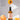 Eine Flasche MERME Berlin FACIAL CLEANSING OIL mit Grapefruit steht zwischen frischen Aprikosen, aus einer tropft Öl. Der deutsche Text erklärt, wie Bio-Aprikosenkernöl während der Reinigung hilft, die Haut auszugleichen.