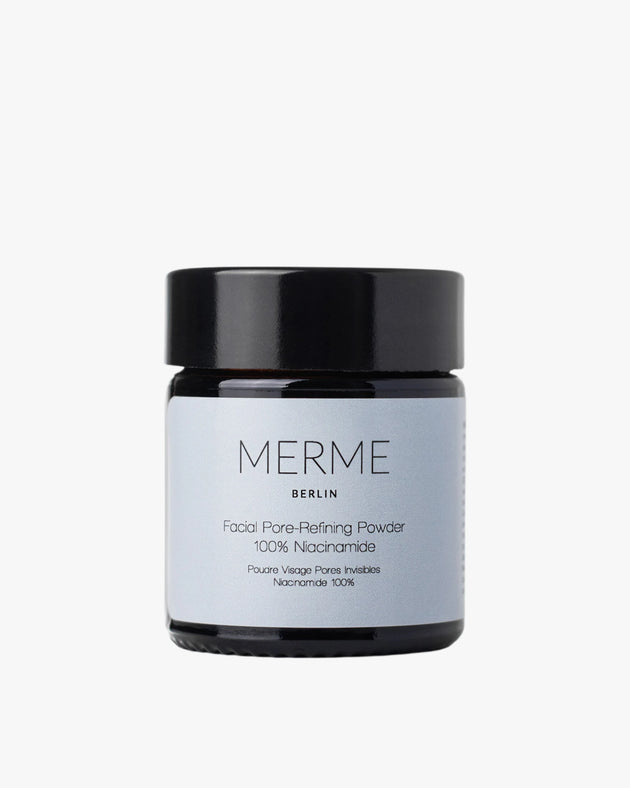 Vor weißem Hintergrund steht ein dunkles Glasgefäß mit schwarzem Deckel und der Aufschrift „MERME Berlin FACIAL PORE-REFINING POWDER“ – ideal für unreine Haut und für sichtbar verfeinerte Poren.
