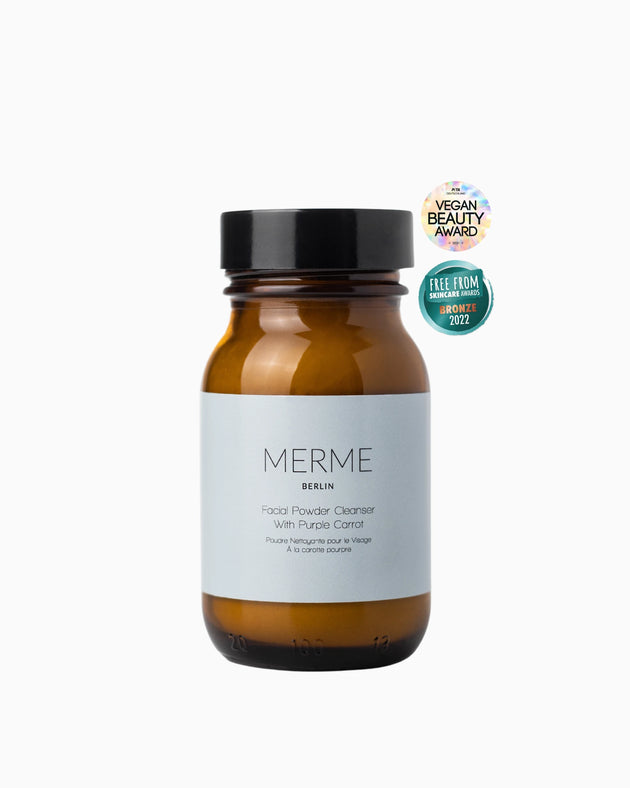 Braunes Glasgefäß mit der Aufschrift „MERME Berlin FACIAL POWDER CLEANSER mit Purple Carrot“. Dieses Puder sorgt für einen tiefenreinigenden Peeling-Effekt. Es wurde mit dem Vegan Beauty Award und den Free From Skincare Awards 2022 ausgezeichnet.