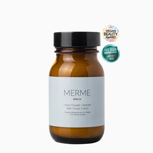 Braunes Glasgefäß mit der Aufschrift „MERME Berlin FACIAL POWDER CLEANSER mit Purple Carrot“. Dieses Puder sorgt für einen tiefenreinigenden Peeling-Effekt. Es wurde mit dem Vegan Beauty Award und den Free From Skincare Awards 2022 ausgezeichnet.