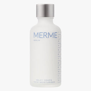 Eine weiße Flasche mit silbernem Deckel mit der Aufschrift „MERME BERLIN“ und „MILKY DROPS FACE MOISTURISER“ und Messmarkierungen an der Seite.