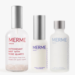 Das PRIME. REFINE. SEAL.-Set von MERME Berlin enthält drei minimalistische Hautpflegeflaschen, jeweils mit silbernen und weißen Verschlüssen, darunter Antioxidant Mist mit Rosenwasser und Rosenquarz, Pore & Line Refine Serum mit Niacinamid und Milky Drops Moisturiser.