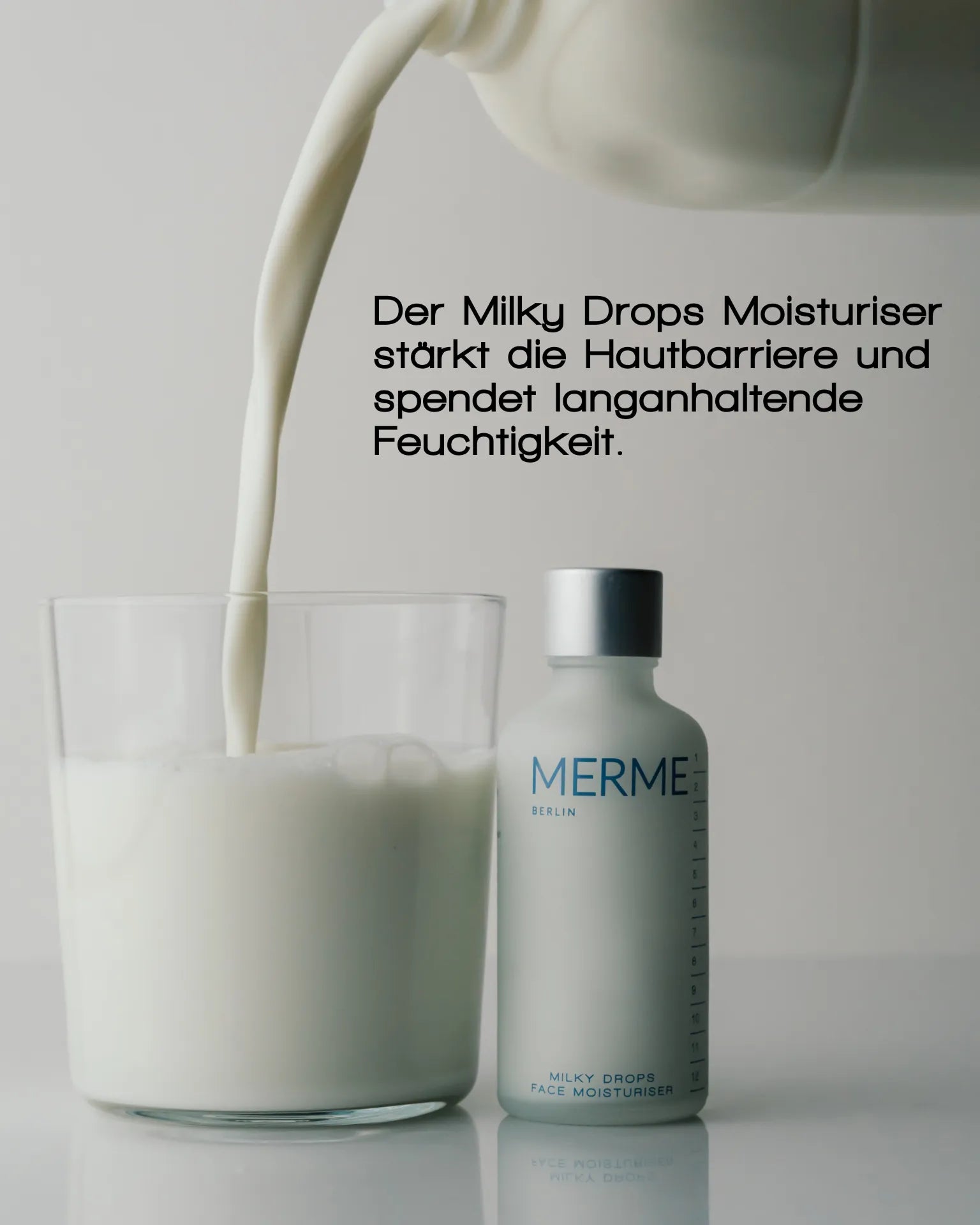 Ein Glas, das mit Milch gefüllt wird, steht neben einer Flasche MERME Berlin PRIME. REFINE. SEAL. Die Vorteile auf Deutsch oben betonen Niacinamid zur Unterstützung der Hautbarriere und für anhaltende Feuchtigkeit.