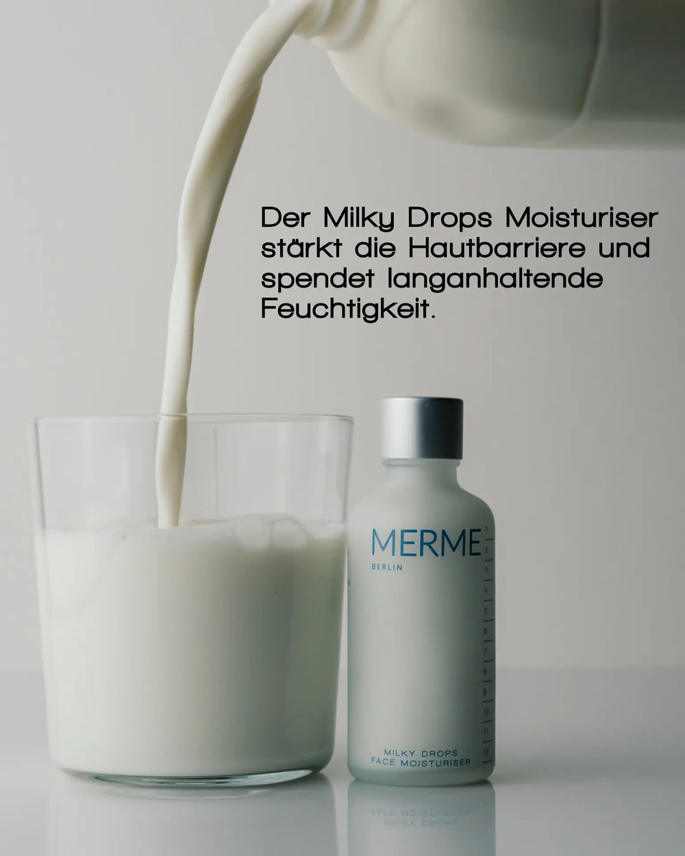 Ein Glas, das mit Milch gefüllt wird, steht neben einer Flasche MERME Berlin PRIME. REFINE. SEAL. Die Vorteile auf Deutsch oben betonen Niacinamid zur Unterstützung der Hautbarriere und für anhaltende Feuchtigkeit.