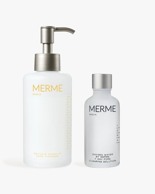 Zwei MERME Berlin Hautpflegeprodukte - CLEANSE & CLEAR: eine weiße Pumpflasche Reinigungsmittel und eine kleinere gefrostete Flasche Porenlösung - sind auf weißem Hintergrund abgebildet.