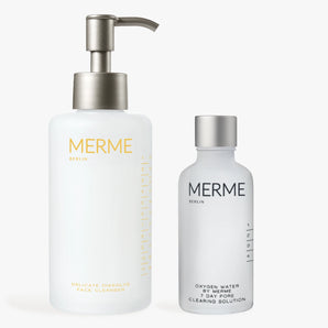 Zwei MERME Berlin Hautpflegeprodukte - CLEANSE & CLEAR: eine weiße Pumpflasche Reinigungsmittel und eine kleinere gefrostete Flasche Porenlösung - sind auf weißem Hintergrund abgebildet.