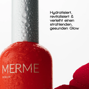 Nahaufnahme einer roten MERME Berlin FRESH DEW FACE MIST Flasche mit Wassertröpfchen, daneben ein rotes Blütenblatt. Der schwarze Text beschreibt es als feuchtigkeitsspendend und revitalisierend, um der Haut ein strahlendes, gesundes Aussehen zu verleihen.