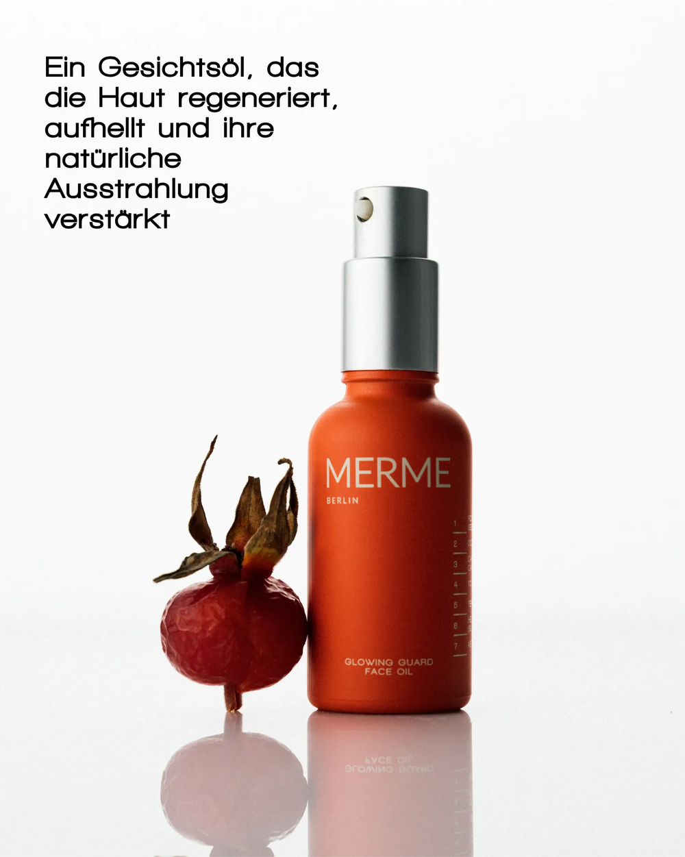 Eine orangefarbene Flasche MERME Berlin GLOWING GUARD FACE OIL steht neben einer roten Hagebuttenfrucht auf einem weißen Hintergrund. Der deutsche Text hebt die Vorteile für die Regeneration der Haut, die natürliche Ausstrahlung und einen strahlenden Teint hervor.