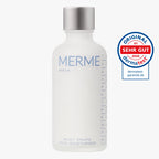Weiße MERME Berlin Milky Drops Face Moisturiser Flasche mit silbernem Verschluss, daneben ein rundes Siegel "Original Dermatest Sehr Gut 2026". Ideale feuchtigkeitsspendende Pflege mit Peptiden und Ceramiden.