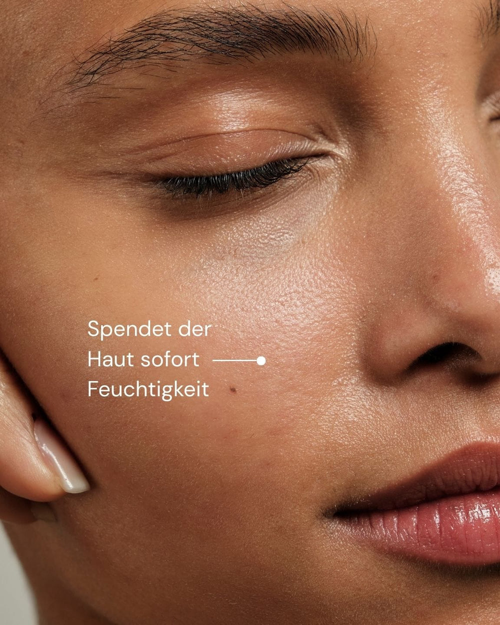 Nahaufnahme des Gesichts einer Person mit glatter, hydrierter Haut und geschlossenen Augen. Text auf Deutsch: "Spendet der Haut sofort Feuchtigkeit." More Moisture Face Serum von MERME Berlin - Feuchtigkeitsserum mit Hyaluronsäure zur Stärkung der Hautbarriere.