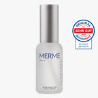 Eine Milchglasflasche mit der Aufschrift "MERME Berlin More Moisture Face Serum" und einer silbernen Kappe wird neben einem runden blau-roten Dermatest-Siegel mit der Aufschrift "Sehr Gut 2026" gezeigt.