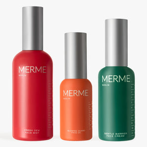 Drei MERME Berlin Hydrate. Verjüngen. Strahlen: Die organischen Produkte - roter Gesichtsnebel, oranges Gesichtsöl und grüne Feuchtigkeitscreme - stehen aufrecht mit silbernen Kappen auf weißem Hintergrund.