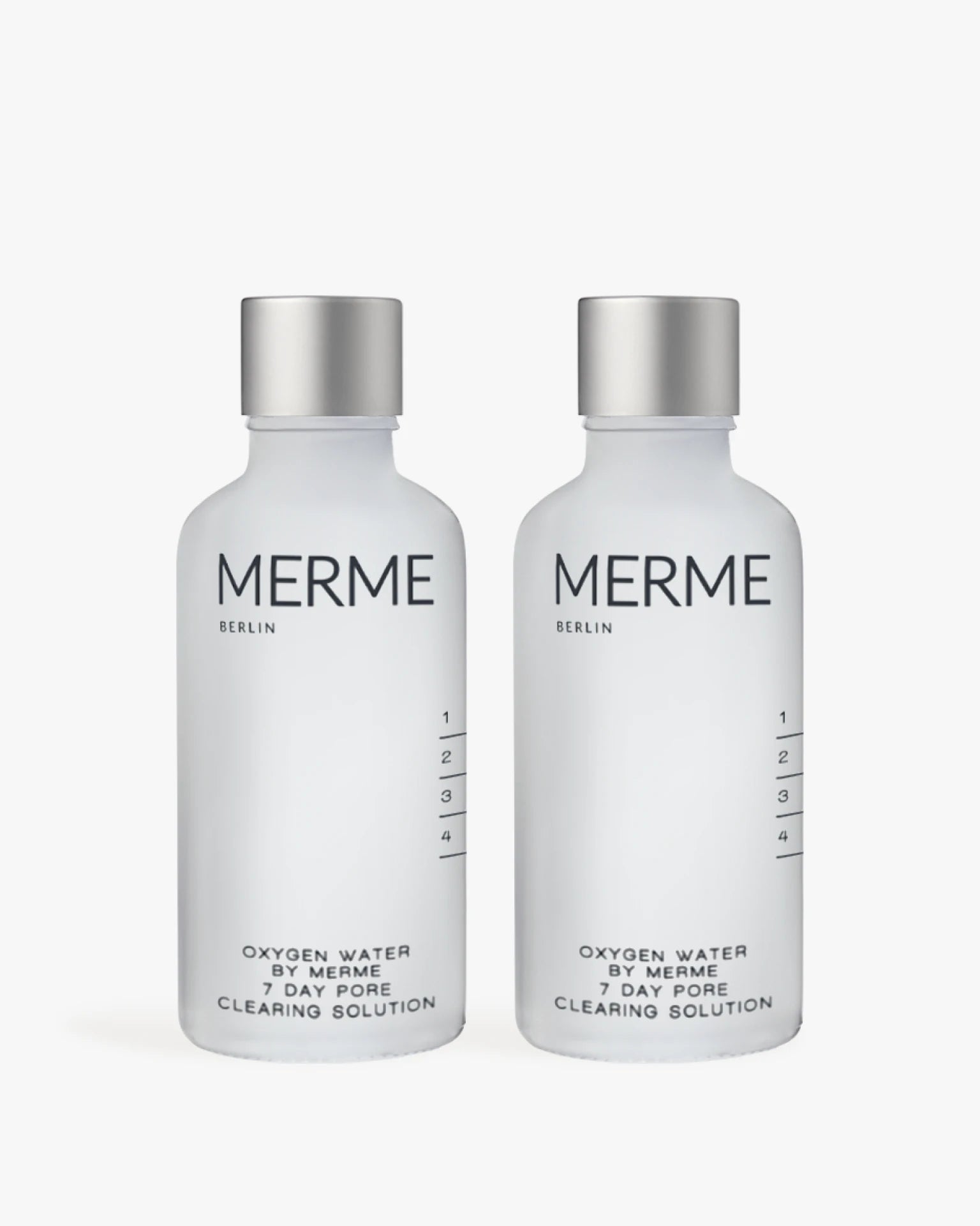Zwei mattierte Flaschen mit der Aufschrift "MERME Berlin OXYGEN WATER PORE CLEARING SOLUTION - 2 WOCHEN" stehen nebeneinander und sind mit einem minimalistischen schwarzen Text versehen. Diese Sprays nutzen die Sauerstoff-Microbubble-Technologie für eine effektive Hautpflege.