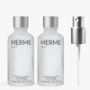 Zwei durchsichtige Flaschen mit der Aufschrift "OXYGEN WATER BY MERME 2-WOCHEN-SET" von MERME Berlin stehen nebeneinander und sind mit der fortschrittlichen Sauerstoff-Microbubble-Technologie für eine effektive Porenreinigung ausgestattet. Rechts daneben sitzt eine silberne Sprühdüse auf einem schlichten Hintergrund.