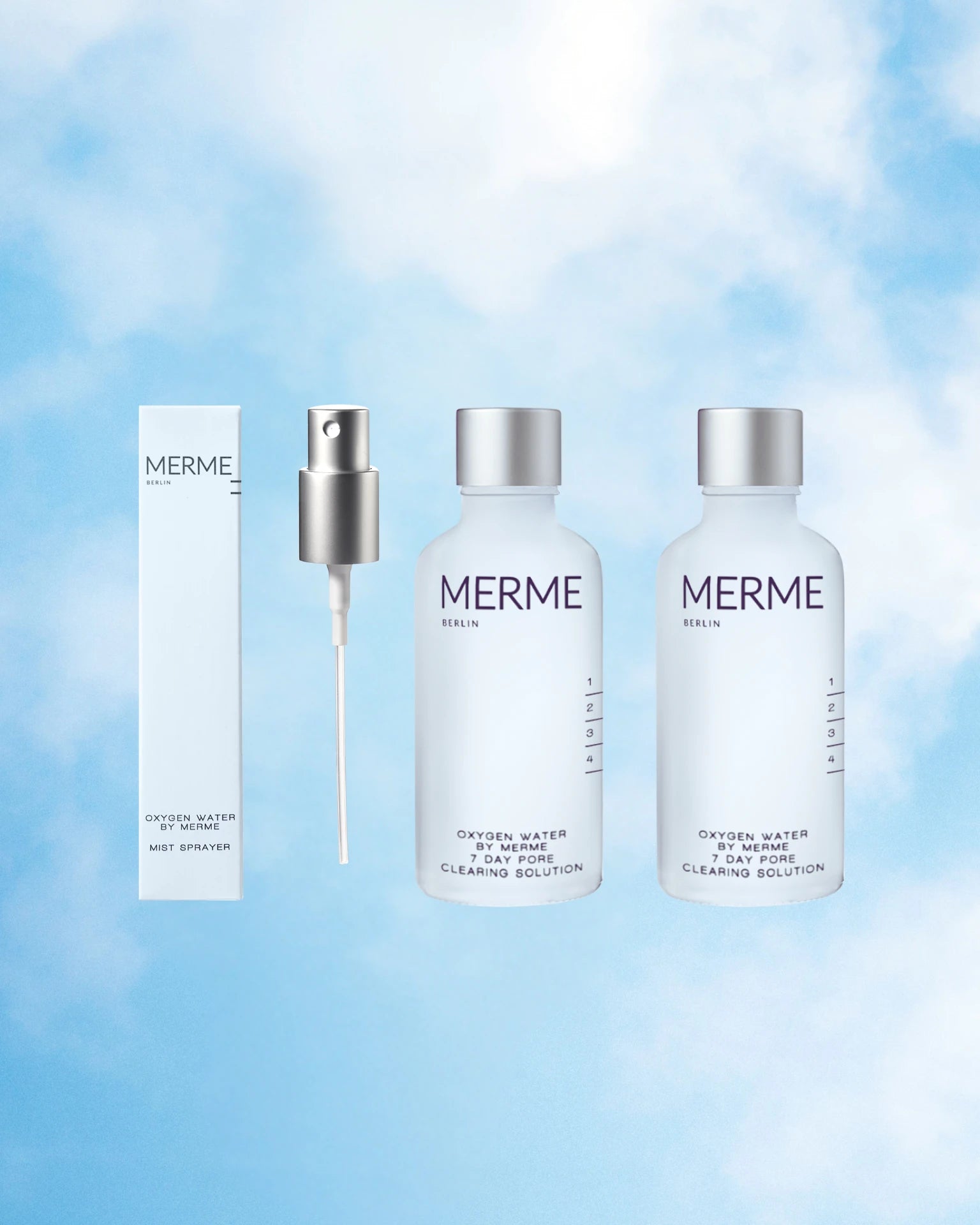 Das OXYGEN WATER BY MERME 2-WOCHEN-SET von MERME Berlin, bestehend aus zwei Flaschen, einem silbernen Zerstäuber und einer weißen Schachtel, wird vor einem himmelblauen Wolkenhintergrund gezeigt, der die Sauerstoff-Microbubble-Technologie hervorhebt.