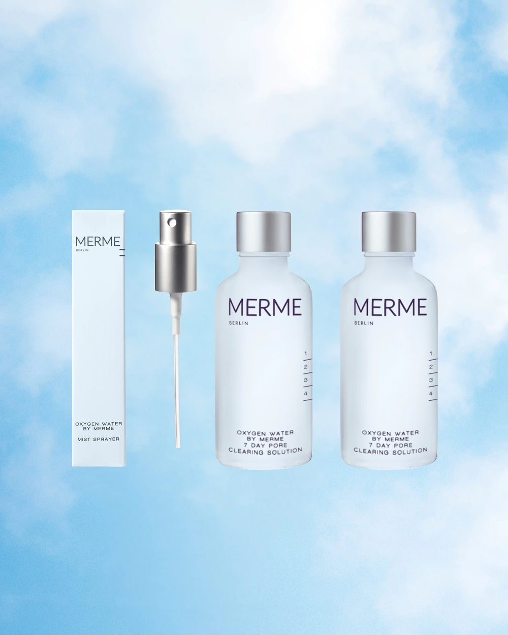 Das OXYGEN WATER BY MERME 2-WOCHEN-SET von MERME Berlin, bestehend aus zwei Flaschen, einem silbernen Zerstäuber und einer weißen Schachtel, wird vor einem himmelblauen Wolkenhintergrund gezeigt, der die Sauerstoff-Microbubble-Technologie hervorhebt.