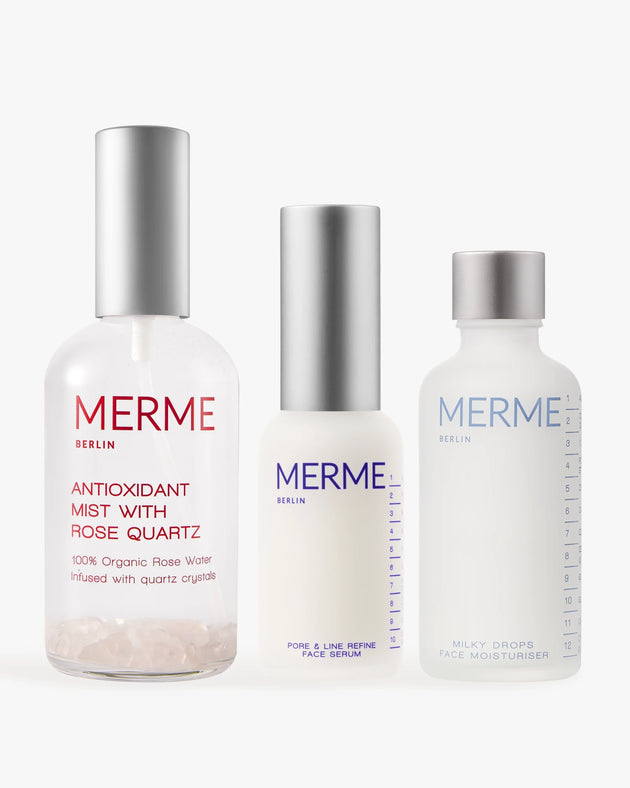 Das PRIME. REFINE. SEAL.-Set von MERME Berlin enthält drei minimalistische Hautpflegeflaschen, jeweils mit silbernen und weißen Verschlüssen, darunter Antioxidant Mist mit Rosenwasser und Rosenquarz, Pore & Line Refine Serum mit Niacinamid und Milky Drops Moisturiser.