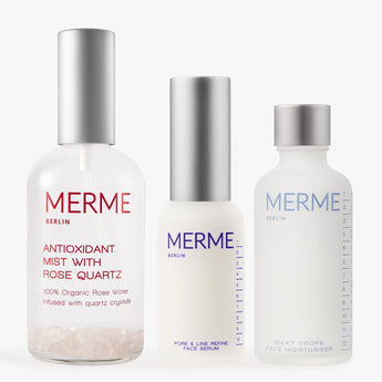 Das PRIME. REFINE. SEAL.-Set von MERME Berlin enthält drei minimalistische Hautpflegeflaschen, jeweils mit silbernen und weißen Verschlüssen, darunter Antioxidant Mist mit Rosenwasser und Rosenquarz, Pore & Line Refine Serum mit Niacinamid und Milky Drops Moisturiser.