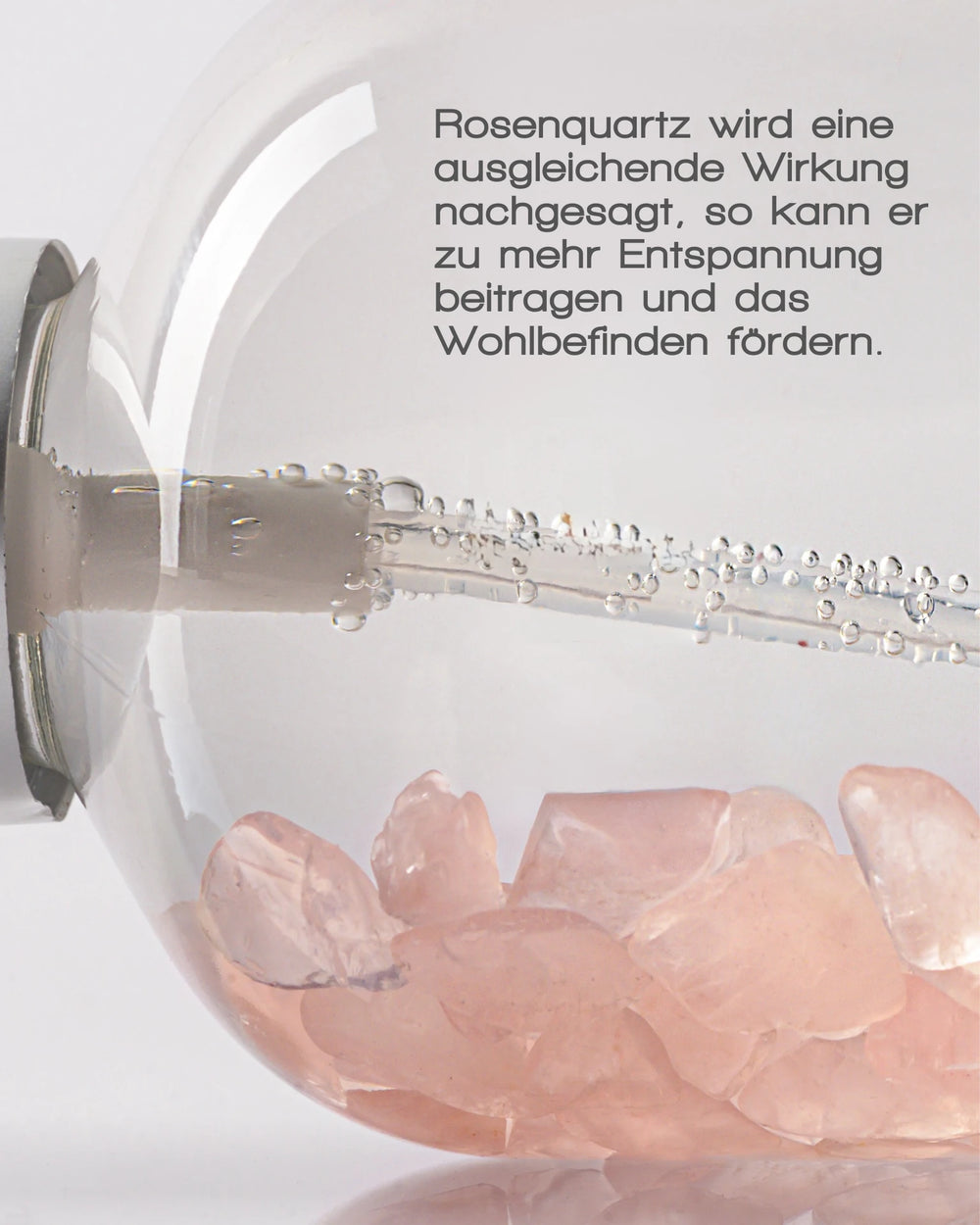 Das ANTIOXIDANT MIST WITH ROSE QUARTZ von MERME Berlin besteht aus rosa Rosenquarzsteinen in perlendem Wasser. Der deutsche Text betont die ausgleichende Wirkung von Rosenquarz, die Entspannung und Wohlbefinden fördert – perfekt als Gesichtsspray oder Rosenwasser.